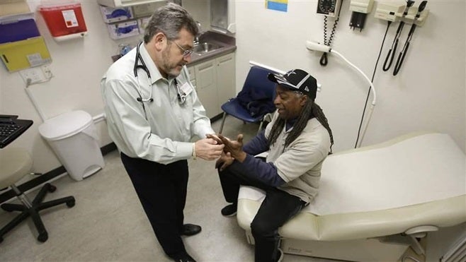 A doctor examines a patient in Sacramento, California. A bipartisan group of governors has proposed health care fixes to stab