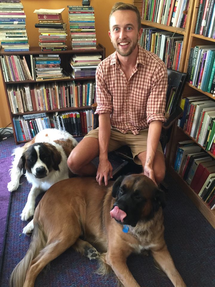 Zane DeZeeuw, summer intern, in the Sinister Wisdom offices with Samantha on the left and Tiberius (with his tongue out) on the right.
