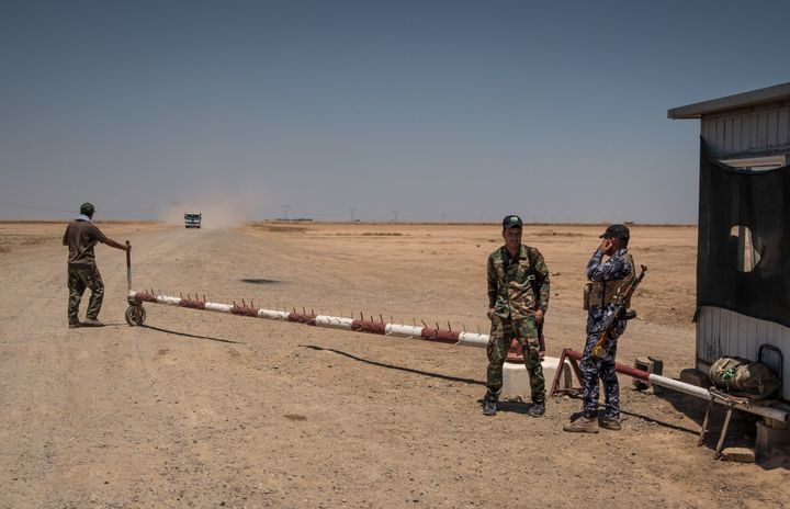 Shiite militiamen guarding the entrance to a desert road in Diyala Province that begins near the Iranian border.