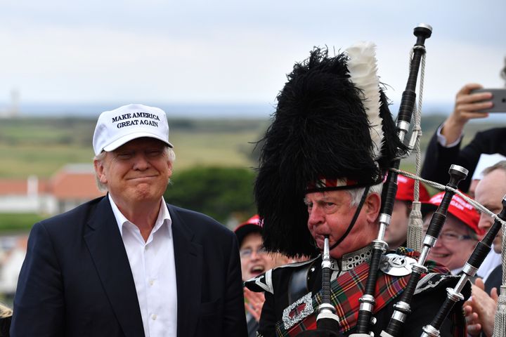 A bagpipe player wears traditional dress next to Presumptive Republican nominee for US president Donald Trump as he arrives to his Trump Turnberry Resort in 2016.