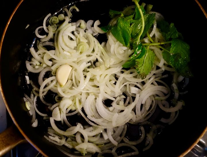 Flavor the onion with a clove of garlic and some mint