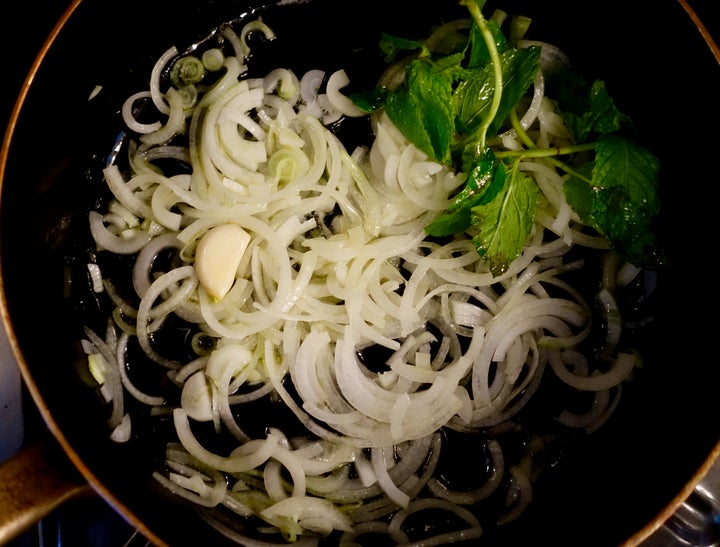 Flavor the onion with a clove of garlic and some mint