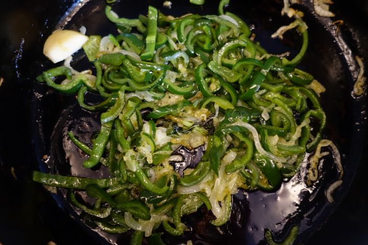 Two poblano peppers go in when the onions are getting soft
