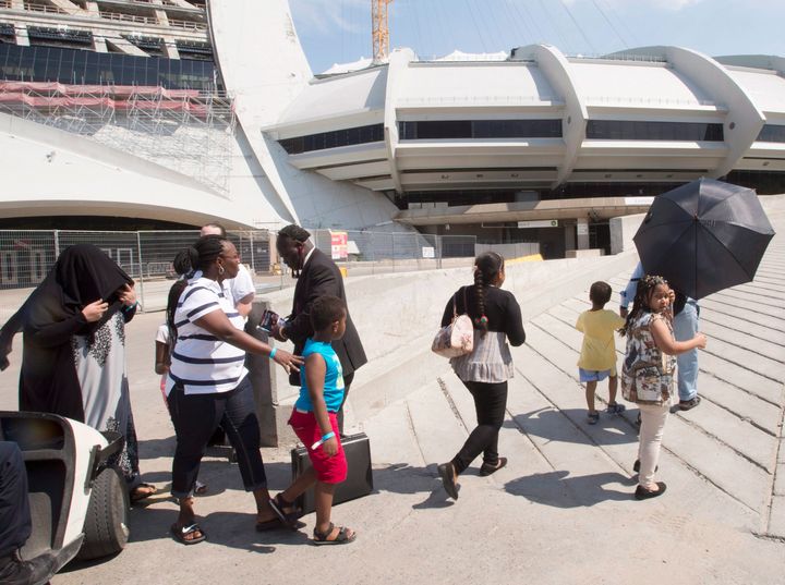 A group of asylum seekers leave Olympic Stadium to go for a walk, in Montreal on Wednesday, August 2, 2017.