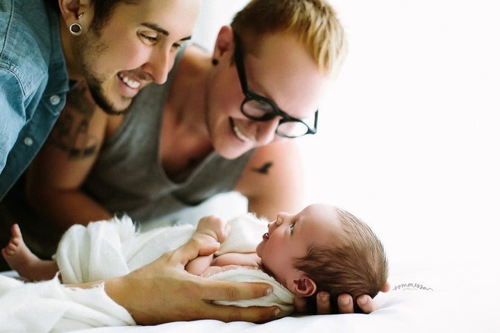 Trystan Reese, left, and Biff Chaplow, right, look down on their new baby Leo.