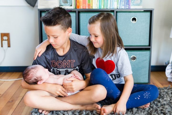 Riley, left, and Hailey, right, look at their new baby brother