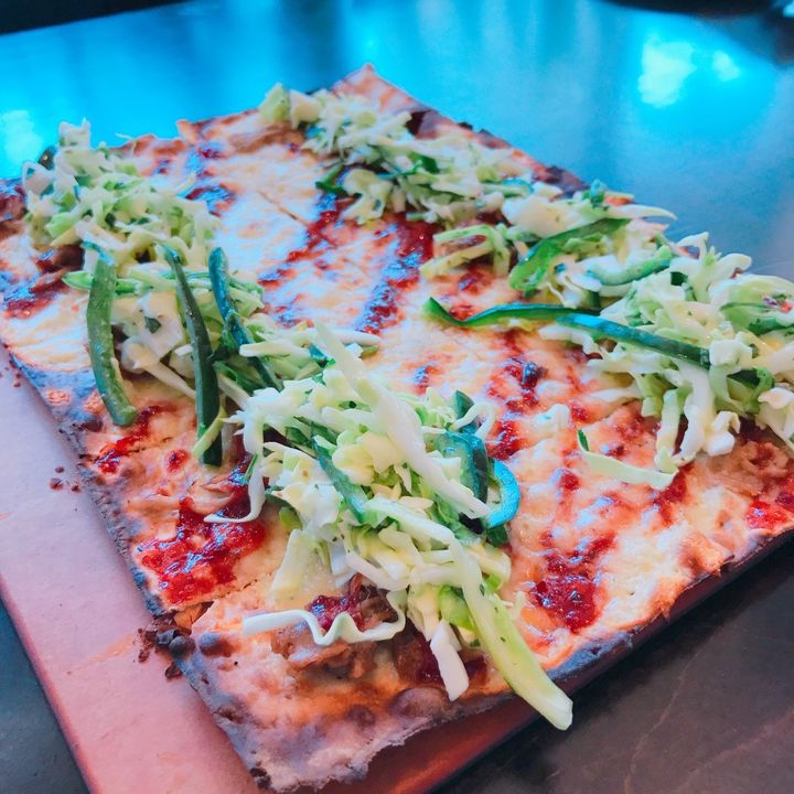 Start things off with a flatbread. Opt for the BBQ Pulled Pork Flatbread which features a chipotle blackberry BBQ sauce, Poblano coleslaw, and mild cheddar.