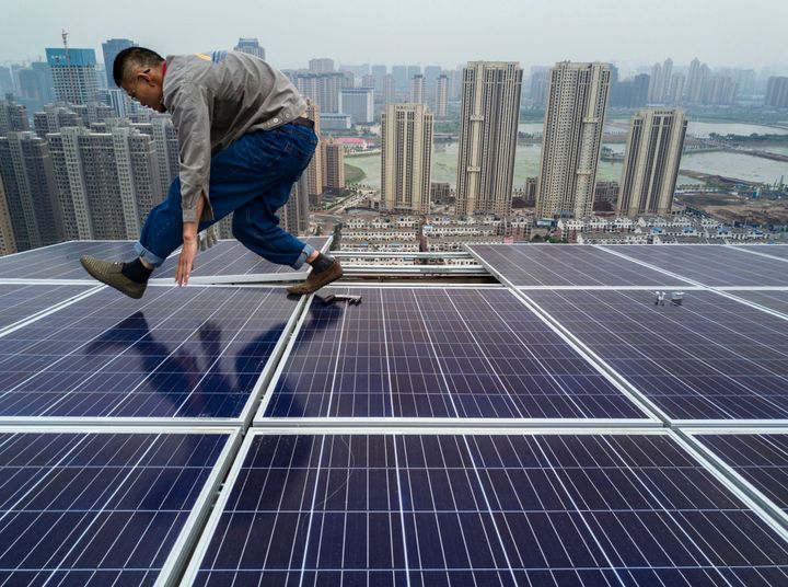 A Chinese worker installing solar panels on the roof of a new building in Wuhan on May 15.