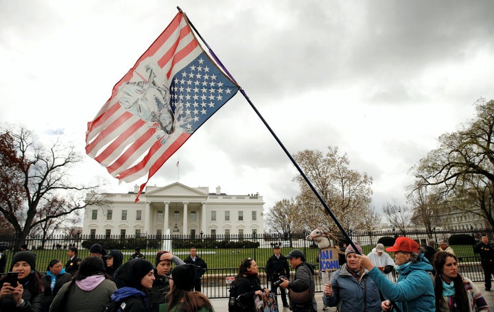 An indigenous activist waves an upside-down U.S. flag with an image of Sitting Bull on it during a protest march and rally in front of the White House on March 10.