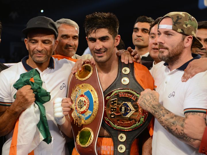 Indian boxer Vijender Singh celebrates after winning the double title bout against China's Zulpikar Maimaitiali in Mumbai on Saturday. 