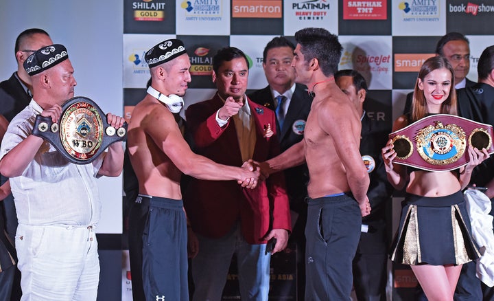 China's Zulpikar Maimaitiali (left) and India's Vijender Singh (right) shake hands during the official weigh-in on Friday bef