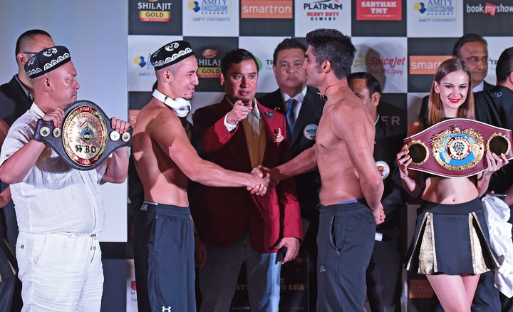 China's Zulpikar Maimaitiali (left) and India's Vijender Singh (right) shake hands during the official weigh-in on Friday before their boxing bout in Mumbai on Saturday.