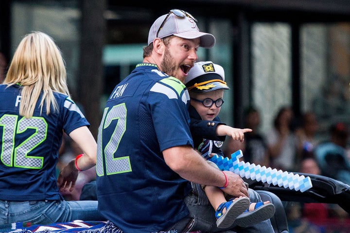 Chris Pratt and son Jack Pratt ride in the Seafair Torchlight Parade.