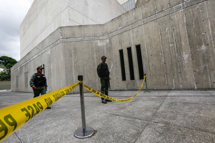 Members of the National Guard stands in the area where according to authorities grenades were thrown from a helicopter, at the Supreme Court in Caracas on June 29.