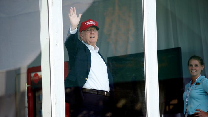 From his personal enclosure at his Bedminster, New Jersey, golf club, President Donald Trump waves to supporters during the U.S. Women's Open on July 15, 2017.