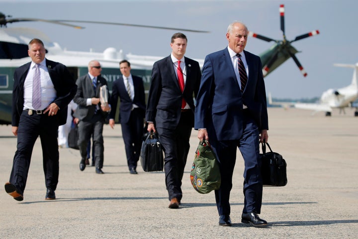 White House chief of staff John Kelly (right) walks with fellow staff to board Air Force One on Aug. 4, 2017.