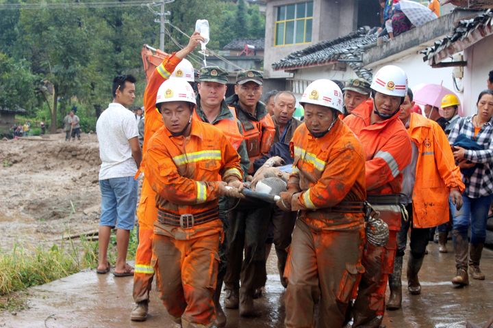 Rescue workers carry an injured villager at the site of a landslide that occurred in Gengdi village, Puge county, Sichuan province. 