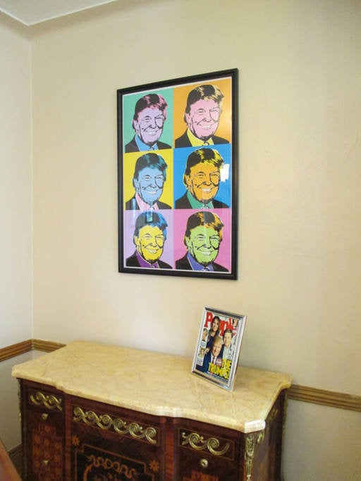 A Trump print and a framed copy of his People magazine cover. 