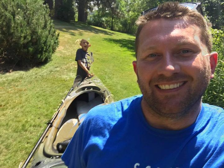 Ryan and dad carting a kayak to the lake while in Idaho
