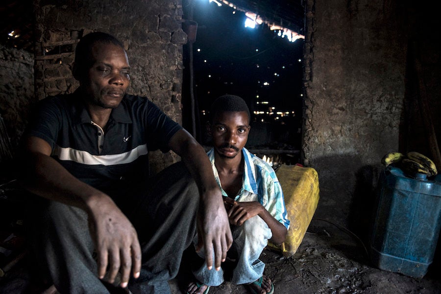 Akolio Bosumbuka at home with one of his sons.