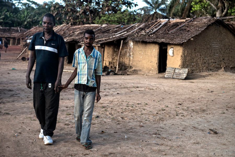 Bosumbuka walks around his village of Salambongo guided by his son who also shows symptoms of river blindness.