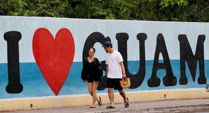 Tourists stroll along a road on the island of Guam on August 10, 2017. 