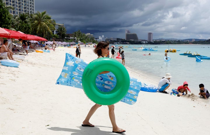 Tourists relax along Tumon beach. 