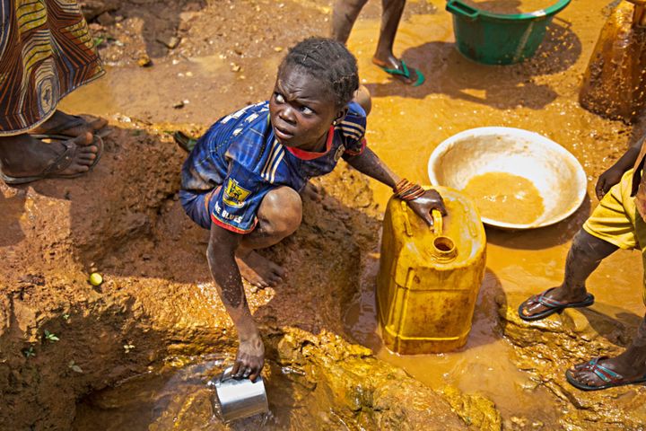 A girl collects water from a spring near a gold mine in Gaga village, CAR. When conflict erupted in October 2013, 58 wells were contaminated with dead bodies and are now unusable, leaving some 8,000 local people who with far fewer places collection points. So far, Concern has built two water pumps and six wells.