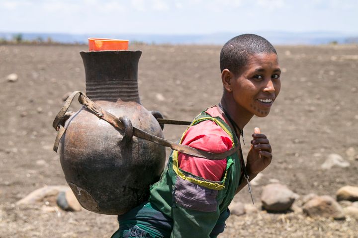 An Ethiopian woman walks home with water that she collected from a tank filled by Concern. Some people, often women, walk up to five hours a day to collect water. 