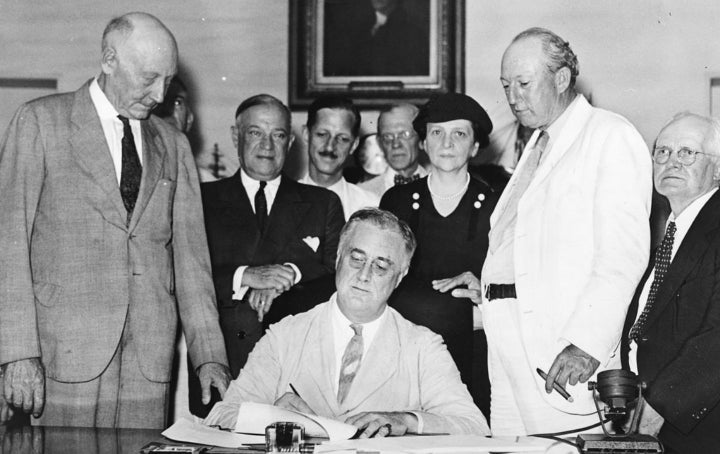 President Franklin D. Roosevelt signs Social Security into law.