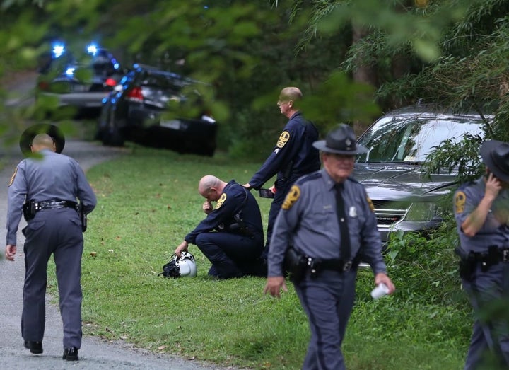 A Virginia law enforcement officer cries near the site of a state police helicopter crash, which killed two state troopers.