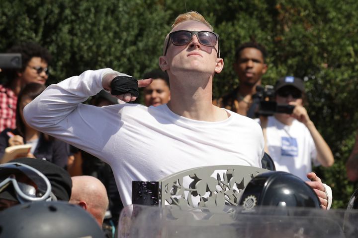 A man makes a slashing motion across his throat toward counter-protesters as he marches with white nationalists, neo-Nazis and members of the "alt-right" during Saturday's "Unite the Right" rally in Charlottesville.