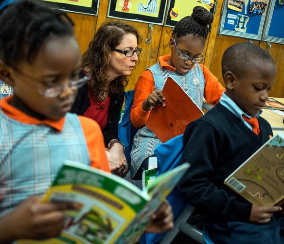 <p>Eva poses for a photo op with Black children to promote her charter school network.</p>