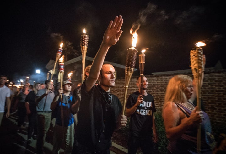 White supremacists and white nationalists carry lit Tiki torches while marching through the University of Virginia campus on