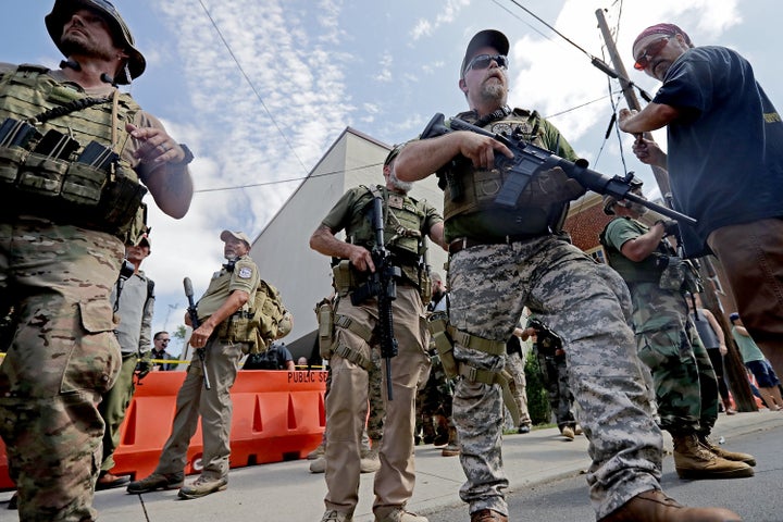 Armed militia members look on after Saturday's "United the Right" rally in Charlottesville was declared an unlawful gathering. 