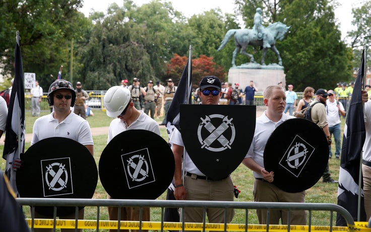 White supremacists, holding shields with a symbol of Vanguard America on them, gather under a statue of Robert E. Lee during a rally in Charlottesville, Virginia, U.S., August 12, 2017. 