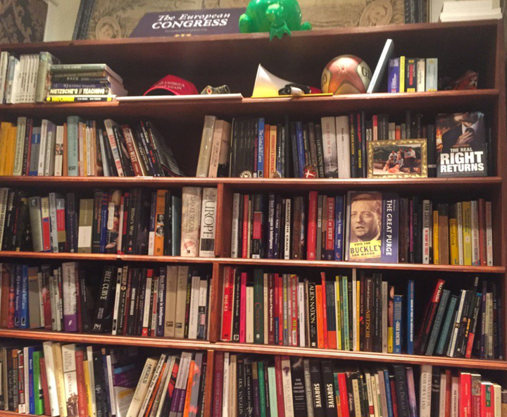 A Trump campaign hat and right-wing books fill shelves in the makeshift office in Alexandria, Virginia.