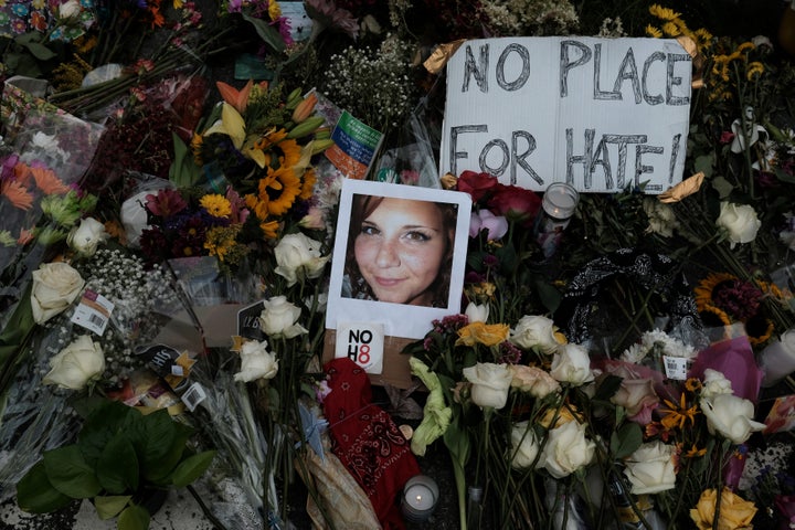 A photo of Heather Heyer placed among flowers left at the scene of where she died, after a car plowed into her and other coun
