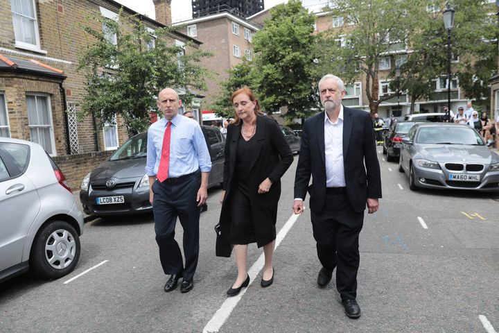 Labour leader Jeremy Corbyn visits the scene of the Grenfell Tower fire with Labour MP for Kensington, Emma Dent Coad (C).