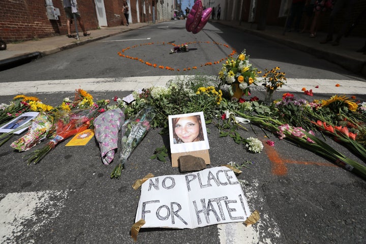 Flowers surround a photo of 32-year-old Heather Heyer, who was killed when a car plowed into a crowd of people protesting against the white supremacist Unite the Right rally.