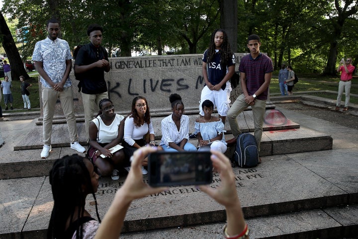A student tour group poses for a photo at the site where a statue dedicated to Robert E. Lee and Thomas 'Stonewall' Jackson stood.