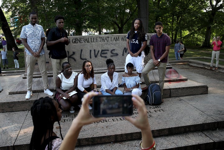 A student tour group poses for a photo at the site where a statue dedicated to Robert E. Lee and Thomas 'Stonewall' Jackson stood. 