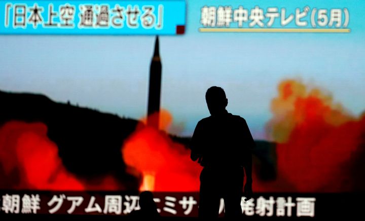 A man walks in front of a monitor showing news of a fresh North Korea threat. Tokyo, Japan. Aug. 10, 2017. 