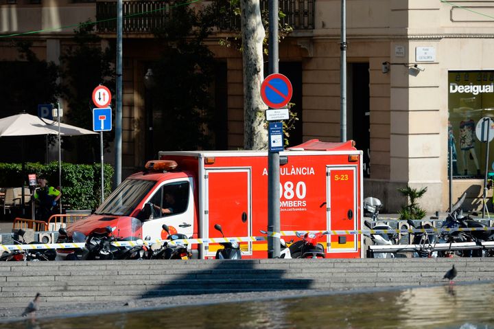 A policeman stands next to an ambulance after a van ploughed into the crowd, injuring several persons on the Rambla in Barcelona