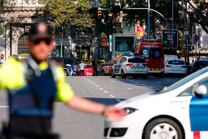 A policemen stand as he blocks the street to a cordoned off area after a van ploughed into the crowd, injuring several persons on Barcelona's Rambla