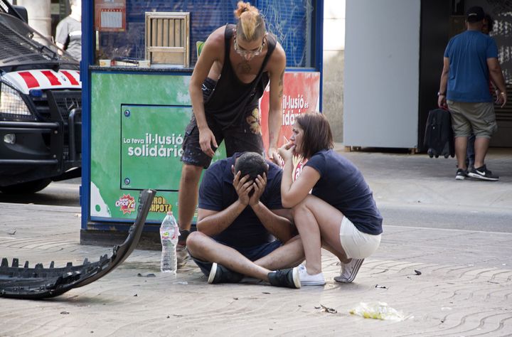 People react after a van crashed into pedestrians in a crowded and popular tourist area in Barcelona Thursday.