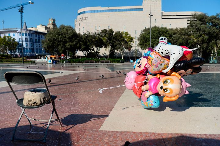 Abandoned air balloons of a street vendor tied to a chair fly at the empty Plaza de Catalunya after the incident