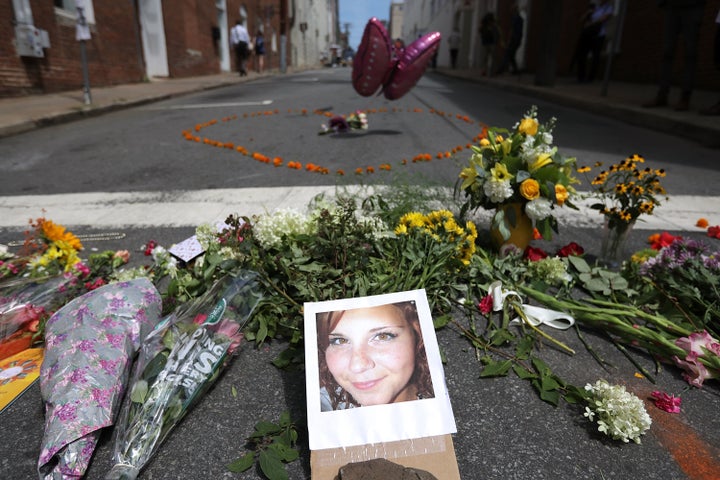 Flowers surround a photo of 32-year-old Heather Heyer, who was killed when a car plowed into a crowd of people protesting aga