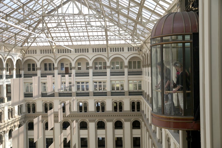 Visitors ride in an elevator at the Old Post Office Pavilion in Washington, D.C., on Thursday, June 20, 2013.