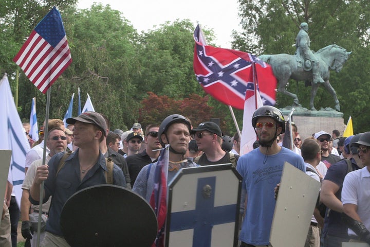 Demonstrators hold shields and flags during the "Unite the Right" rally at Emancipation Park in Charlottesville, Virginia, USA on August 12, 2017.